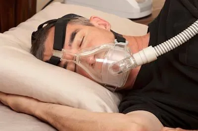 man sleeping soundly at night thanks to a CPAP machine